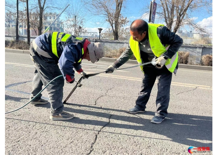 市政工人为裂缝道路贴胶带   守护市民“脚下安全”